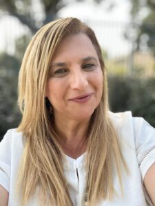 אילנית פורת מצוות מרכז חיוך מחייכת בצילום חוץ