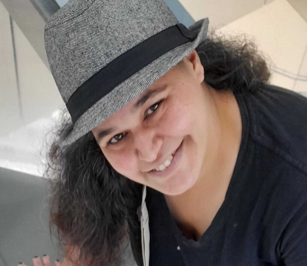 ריקי מרזל פרידמן מצוות מרכז חיוך חובשת כובע ומחייכת