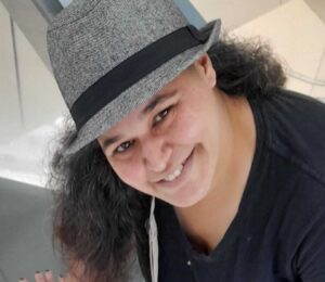 ריקי מרזל פרידמן מצוות מרכז חיוך חובשת כובע ומחייכת
